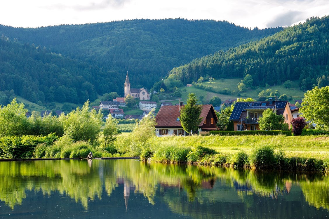 fotos paisajes hermosos y verdes del mundo: casas al lado de un lago con montañas de fondo